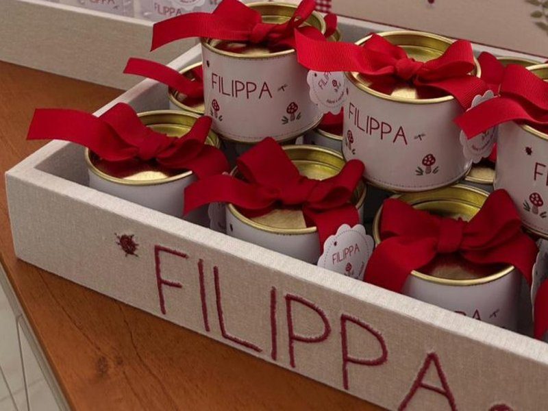 FILIPPA bordado em vermelho em caixa alta na lateral da bandeja de linho, com uma joaninha ao lado