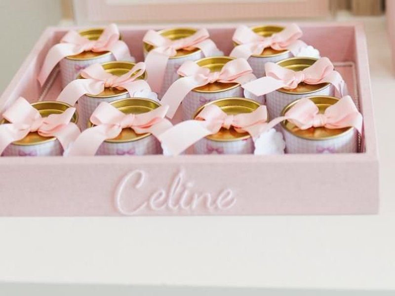 O nome Celine em relevo claro na borda frontal da bandeja rosa