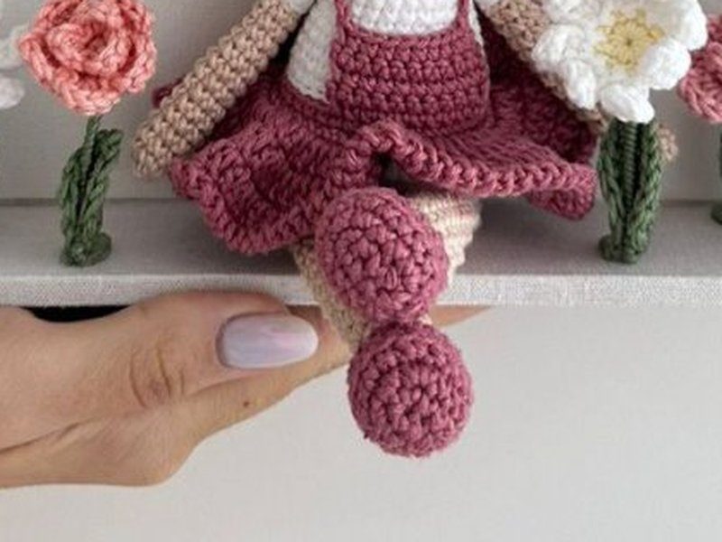 As pernas e os sapatinhos de croch� da boneca penduradas para fora da moldura, apoiadas na borda inferior