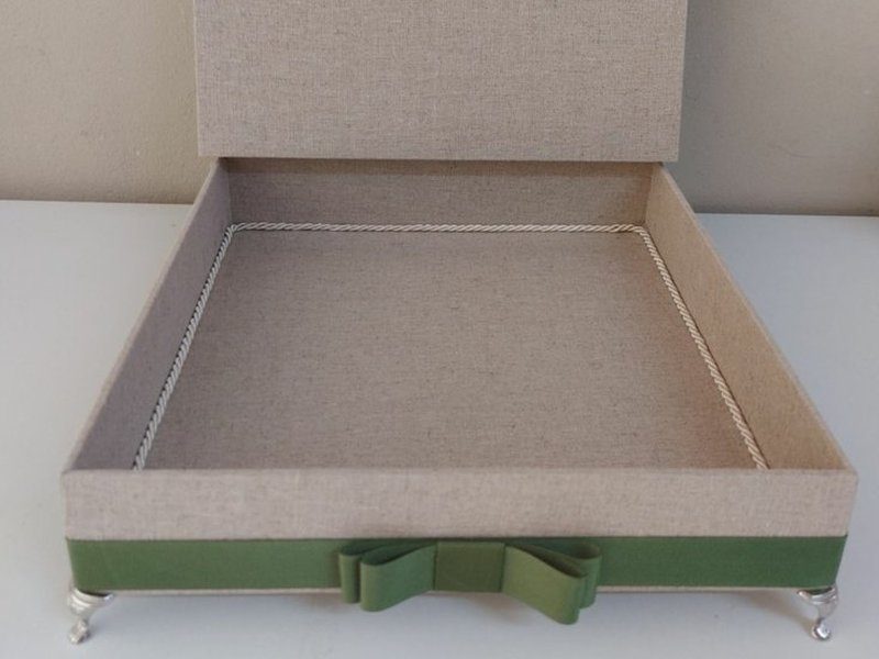 Faixa de gorgur�o verde com la�o na lateral da base, sobre quatro p�s de metal prateado