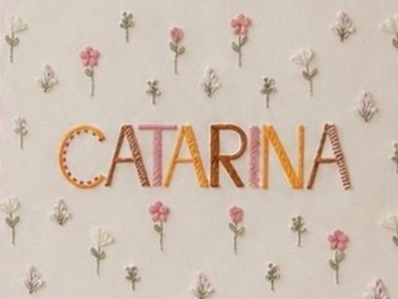 O nome CATARINA com cada letra bordada em cor e padr�o diferentes - lisa, listrada e pontilhada