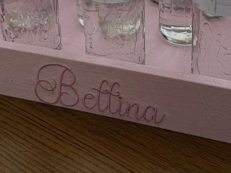 Bettina bordado em cursiva rosa na borda frontal da bandeja de linho