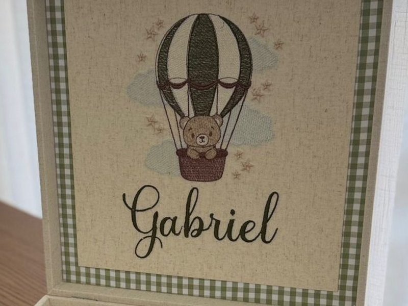 Urso bordado dentro do cesto de um bal�o de ar quente verde-escuro, com estrelinhas e nuvens, e Gabriel em cursiva abaixo
