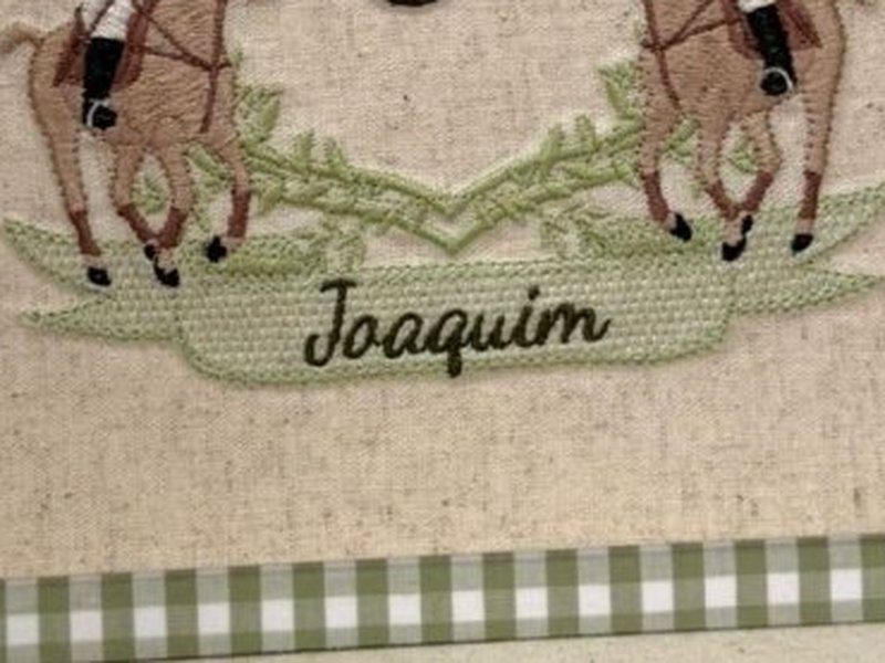 A faixa verde bordada na base com o nome Joaquim escrito em linha escura
