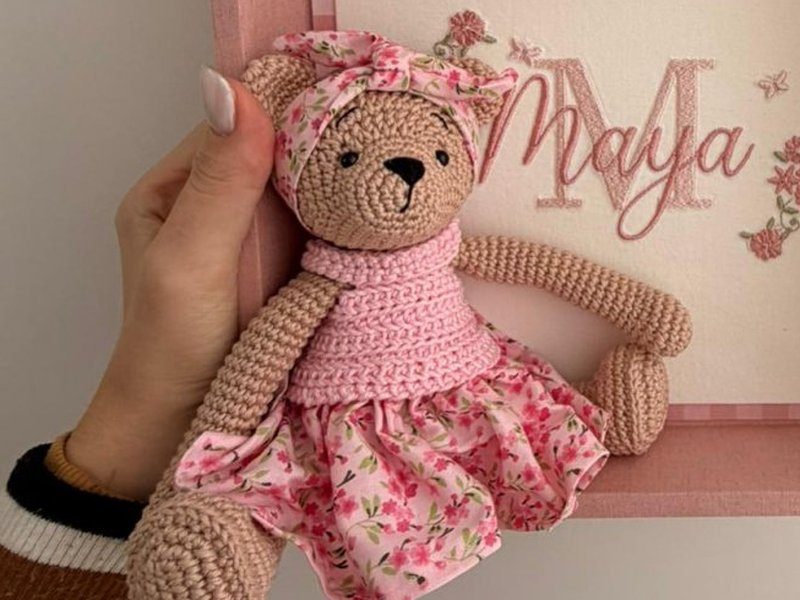 A ursa de croch� com tiara e vestido de tecido floral sobre corpete rosa de croch�
