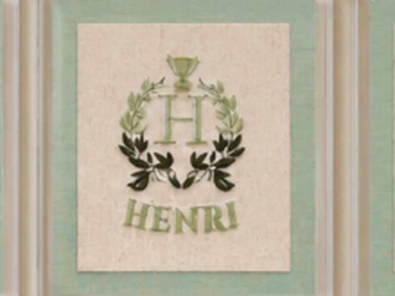 O bras�o de louros com trof�u, a letra H e o nome HENRI bordados