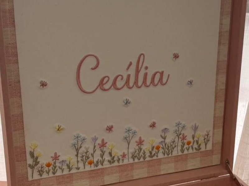 Cec�lia bordado em cursiva rose sobre flores silvestres bordadas em amarelo, lil�s, azul e laranja