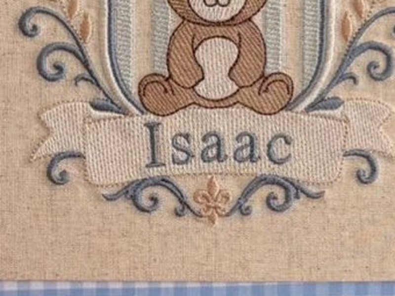 A faixa bordada na base com o nome Isaac e a fleur-de-lis logo abaixo