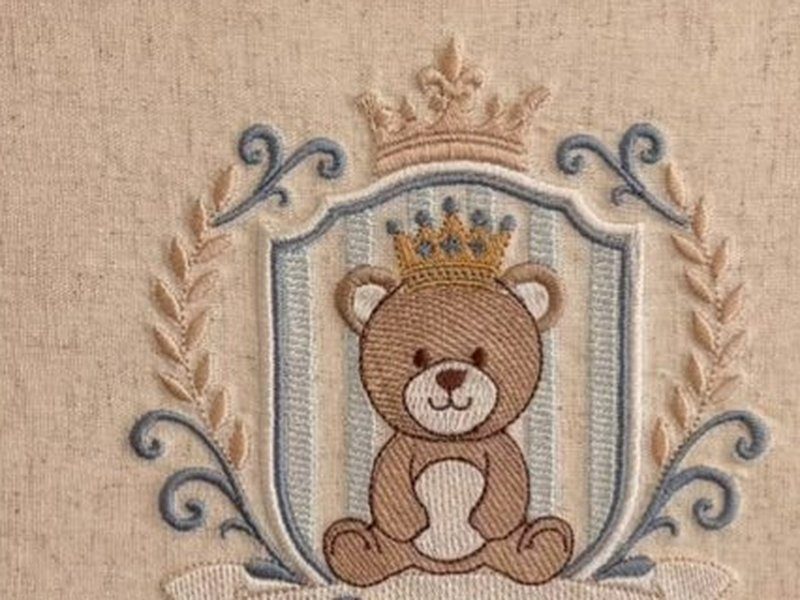 O urso bordado usando coroa dourada dentro do escudo listrado, sob a coroa maior que encima o escudo