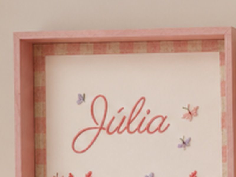O quadro do nome J�lia em cursiva sobre um campo de flores bordadas