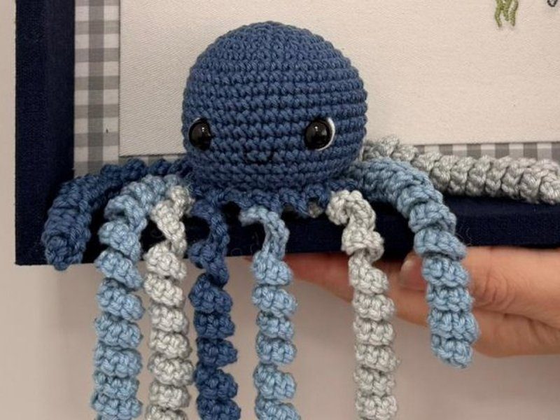 O polvo de croch� azul com os tent�culos em as duas cores caindo para fora do quadro