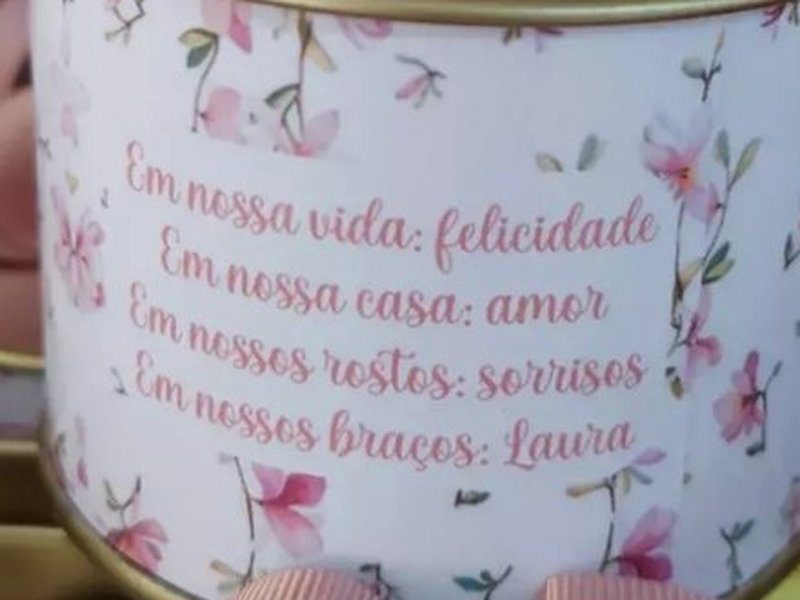 R�tulo de magn�lias com o verso de quatro linhas: Em nossa vida: felicidade / Em nossa casa: amor / Em nossos rostos: sorrisos / Em nossos bra�os: Laura