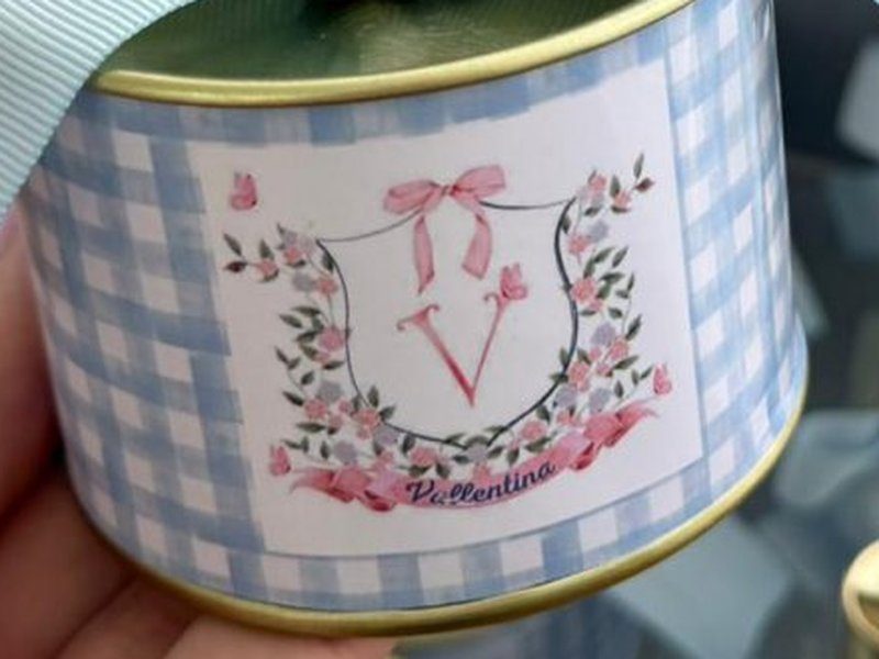 R�tulo em xadrez vichy azul com bras�o floral e a letra V, e o nome Vallentina embaixo